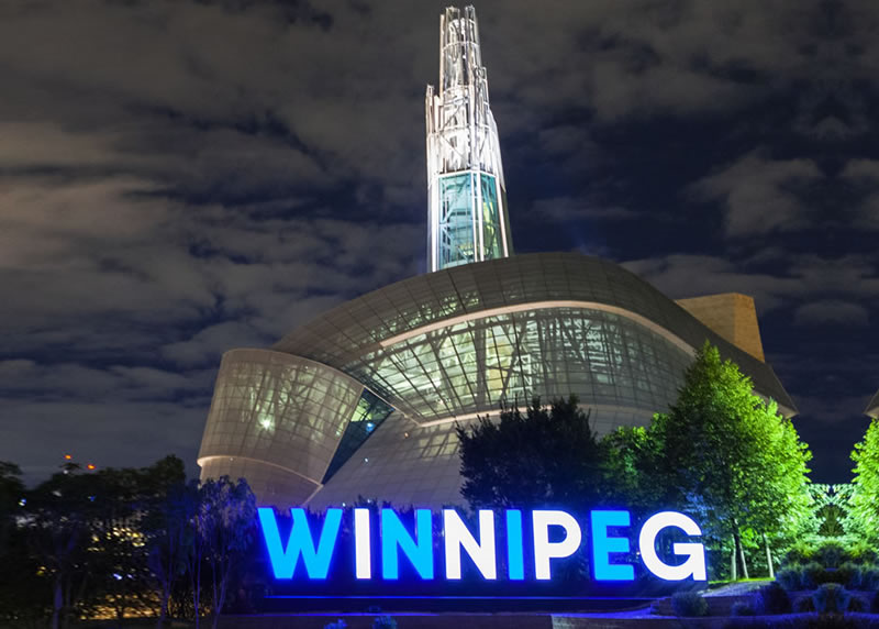 Canadian Museum of Human Rights with Winnipeg sign illuminated at night